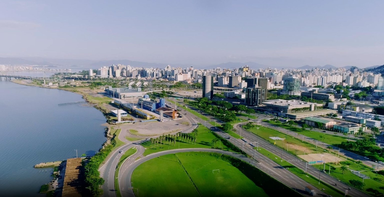 Vista aérea de Florianópolis, com orla, avenida e centro urbano ao fundo